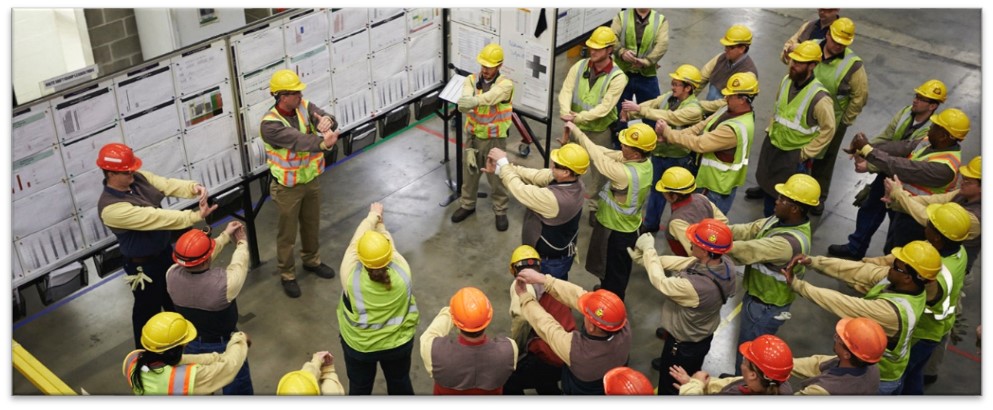 Team reviewing visual management boards and TPS documentation